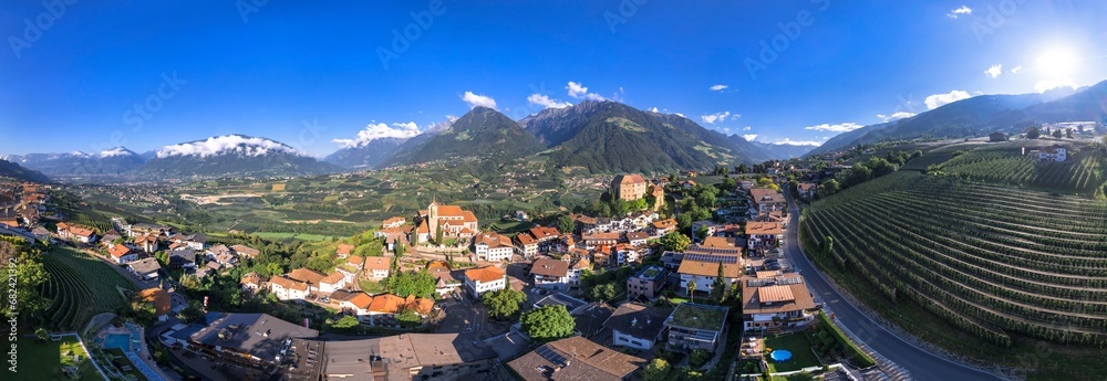 Tourism of northern Italy. Traditional picturesque mountain village Schenna (Scena) near Merano town in Trentino - Alto Adige region. view of medieval castle, aerial  panoramic drone view - obrazy, fototapety, plakaty 