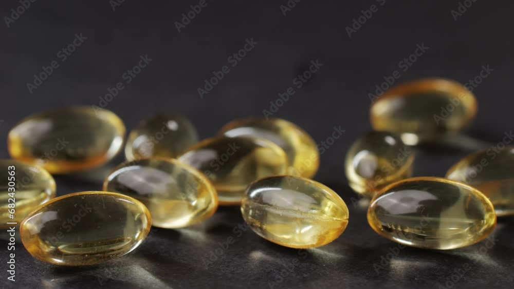 Omega fish oil gel capsules on black background close-up . Omega vitamins pills 3 6 9. To be healthy and take care of your health. Pharmaceutical industry. Business of biological Omega fish oil gel capsules on black background close-up . Omega vitamins pills 3 6 9. To be healthy and take care of your health. Pharmaceutical industry. Business of biological