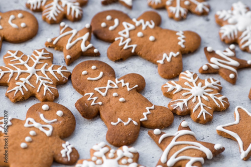 Homemade gingerbread Christmas cookies in icing sugar. Delicious gingerbread cookies on the background of a bokeh of Christmas tree lights. Freshly baked Christmas gingerbread cookies.