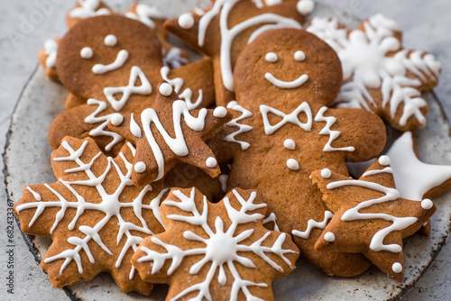 Homemade gingerbread Christmas cookies in icing sugar. Delicious gingerbread cookies on the background of a bokeh of Christmas tree lights. Freshly baked Christmas gingerbread cookies.