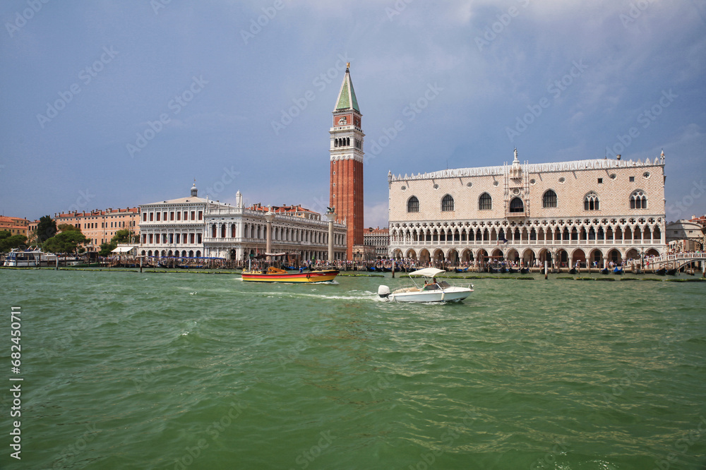 venice view from the canale grande to the marble tower and doge's palace with boats against a blue sky 