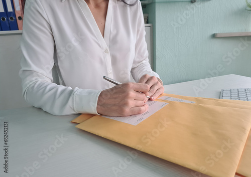 Woman secretary checks received correspondence at workplace concept photo