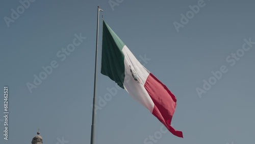Slow Motion of The National Flag of Mexico on Blue Sky - Vertical Tricolor of Green, White, and Red with the National Coat of Arms Charged in the Center of the White Stripe photo