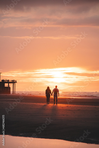 Romantic walk of a young couple on the beaches of Oostende in western Belgium at sunset. Love and devotion. Reflection in a pool of water © Fauren