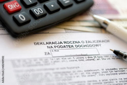Annual declaration of income tax advances, PIT-4R form on accountant table with pen and polish zloty money bills close up