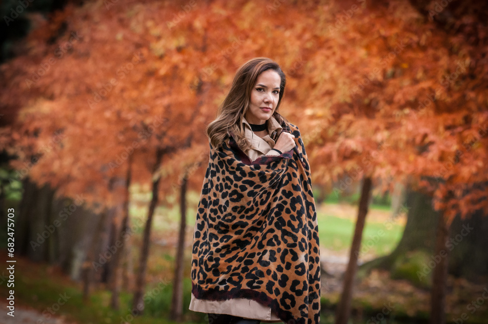 young girl in coat in forest. Fashion woman in coat in park. Slim young fashion model wearing white coat outdoor. Beautiful woman in leopard coat in the autumn park