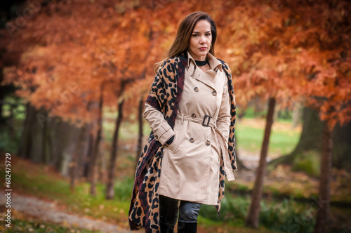 Obraz na płótnie young girl in coat in forest. Fashion woman in coat in park. Slim young fashion model wearing white coat outdoor. Beautiful woman in leopard coat in the autumn park w salonie