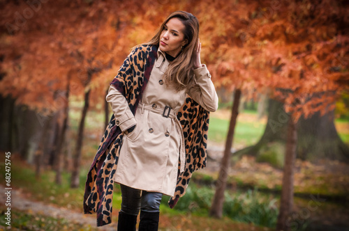 Obraz na płótnie young girl in coat in forest. Fashion woman in coat in park. Slim young fashion model wearing white coat outdoor. Beautiful woman in leopard coat in the autumn park w salonie