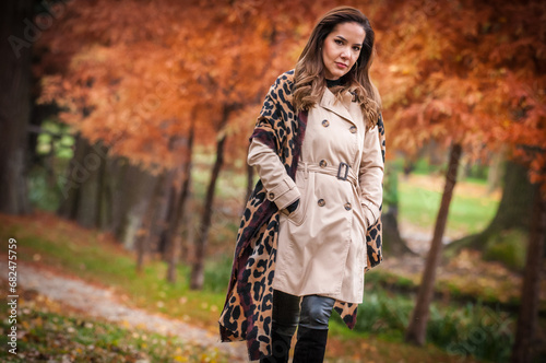 Obraz na płótnie young girl in coat in forest. Fashion woman in coat in park. Slim young fashion model wearing white coat outdoor. Beautiful woman in leopard coat in the autumn park w salonie