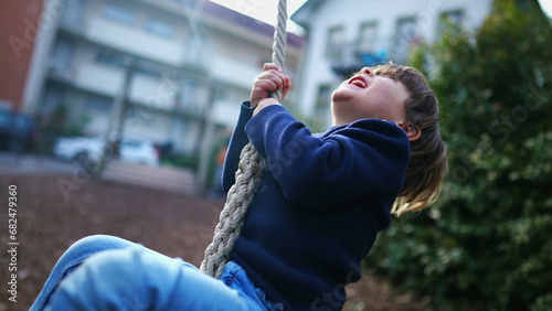 Child Holding Tight and Sliding to End of Wire Rope at Public Park, Young Boy Having Fun in Nostalgic Childhood Moment, Close-Up Slide on Park Wire