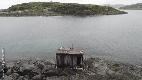 This is the Arctic. Old hunting fishing hut in the skerries (skargard - rocky islets along a rugged coast) of north-eastern Scandinavia. The coast of the Barents Sea photo