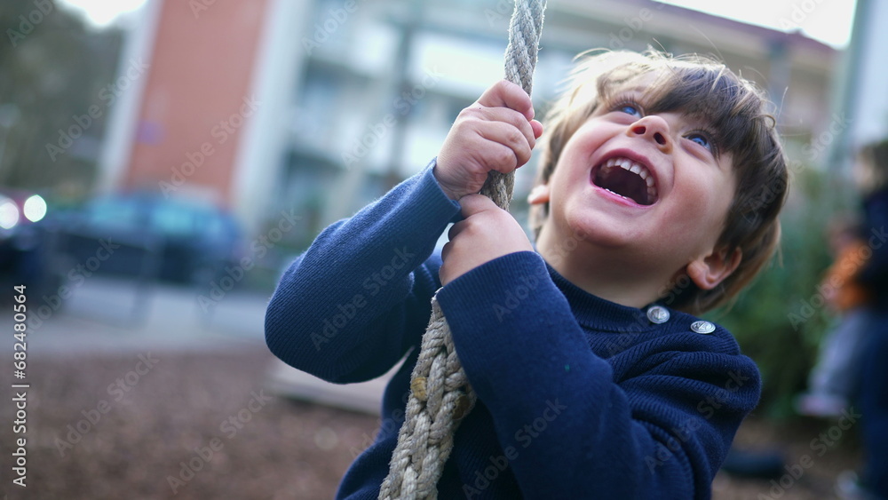 Obraz premium Child Holding Tight and Sliding to End of Wire Rope at Public Park, Young Boy Having Fun in Nostalgic Childhood Moment, Close-Up Slide on Park Wire