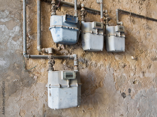 Old methane or propane gas meter placed on a damaged plaster wall photo