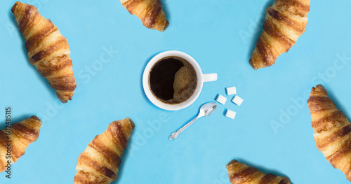 Coffee cup and croissants on the blue background. Top view. Close-up.