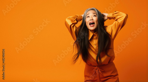 Portrait beautiful asian woman with orange eyes on orange background. asian model.