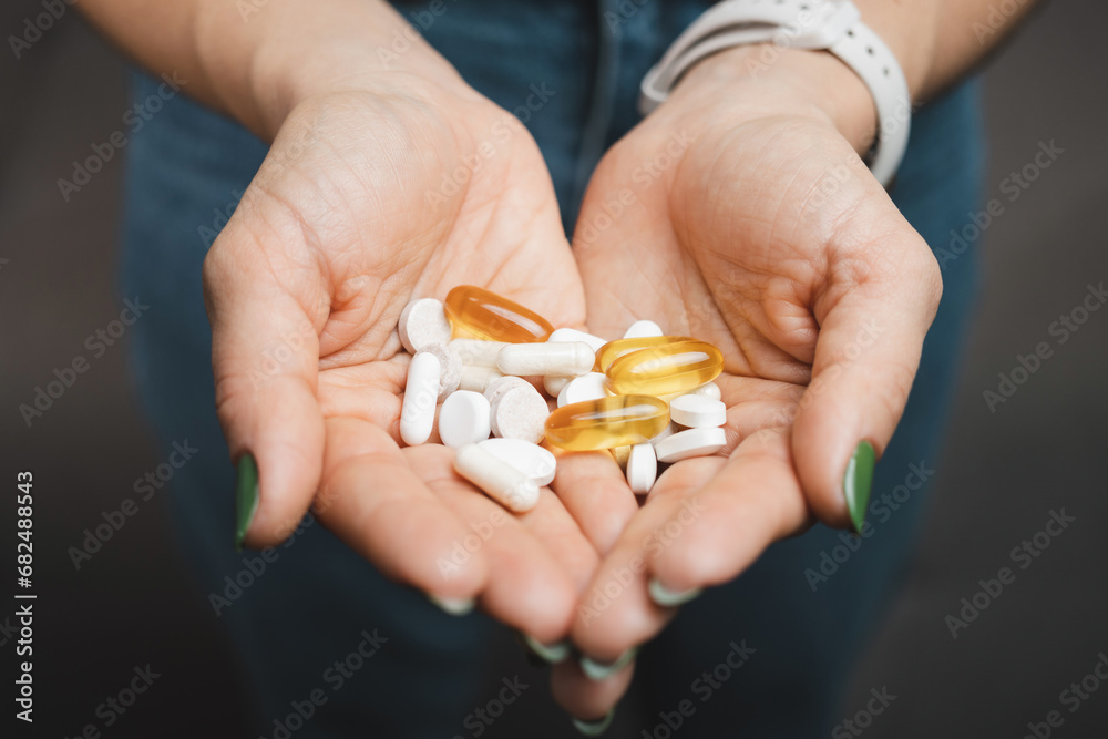 Young woman holds pile of various medical pills and capsules in a hands, close-up view Young woman holds pile of various medical pills and capsules in a hands, close-up view