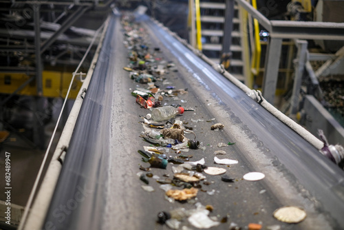 a belt transports glass material to be crushed for subsequent recycling