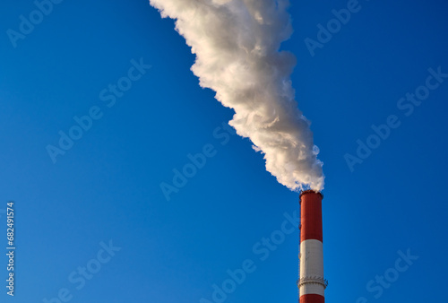white smoke from chimney in a blue sky