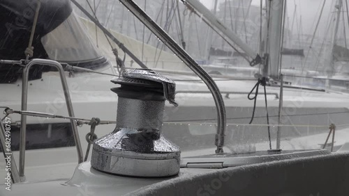 Stainless steel winch on a sailing yacht gets wet in the pouring rain photo