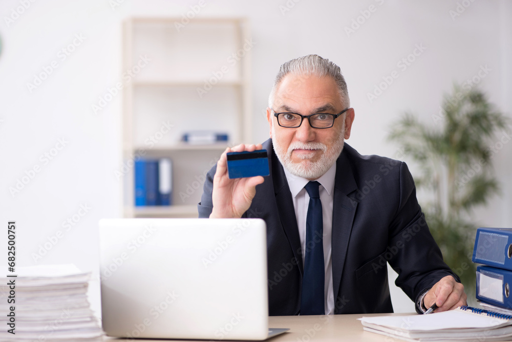 Old male employee working in the office Old male employee working in the office