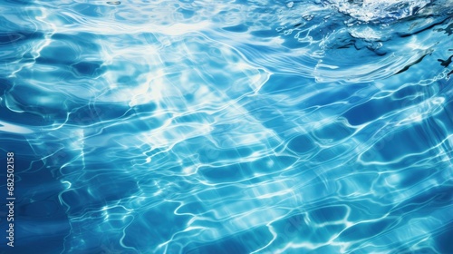 Blue water in swimming pool with sun reflection, motion of ripple wave. © HN Works