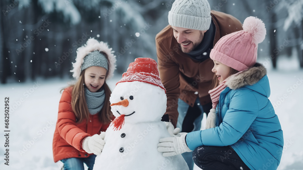 Happy family making snowman in winter park