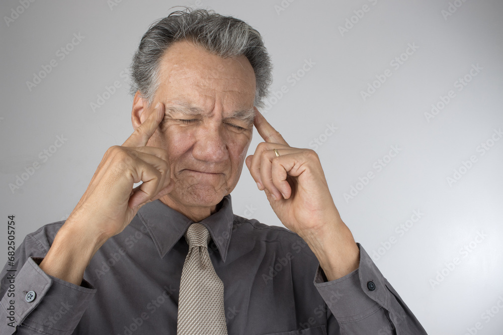 Senior Business Man CEO in deep thought with fingers against his temple thinking of new Ideas Senior Business Man CEO in deep thought with fingers against his temple thinking of new Ideas