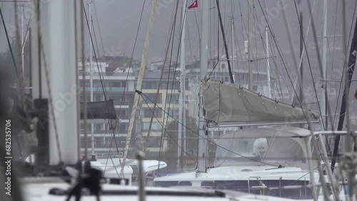 Rain and rolling yachts in the marina. Slow motion.