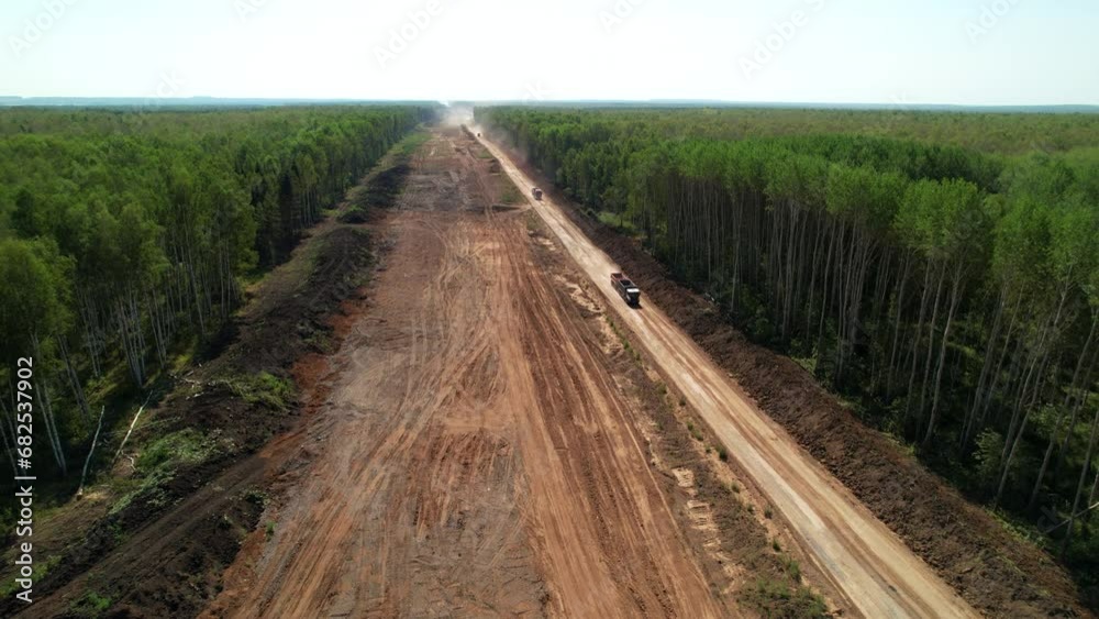 Aerial view. Cutting down trees in the forest for the construction of highways. Construction of a new motorway. Construction of a new road. Top view Aerial view. Cutting down trees in the forest for the construction of highways. Construction of a new motorway. Construction of a new road. Top view