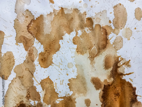 Abstract coffee grunge background. Brown coffee stains on white paper with copy space. Dirty paper with coffee drops. Coffee splash texture with copy space. Modern brown illustration.