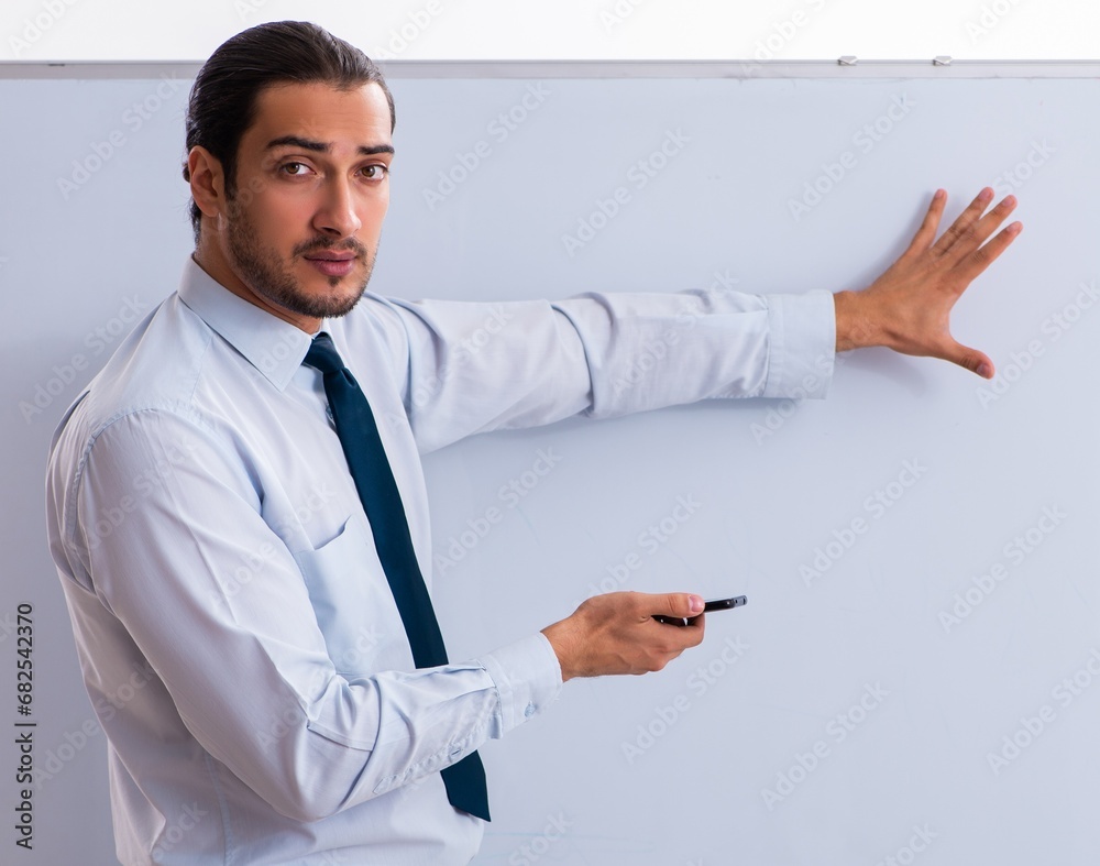 Young male employee in business presentation concept Young male employee in business presentation concept