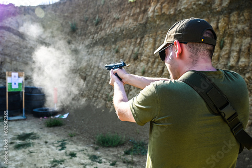 Obraz na płótnie Man shoots a pistol at a target w salonie