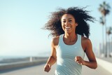 Young afro american woman runner running on city bridge road against blue background