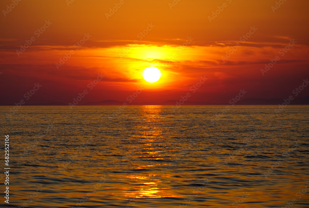 Dramatic orange color tone sky above sea during summer sunset