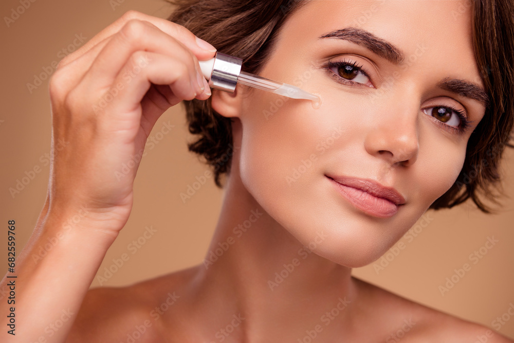 Close up photo of attractive lady applying oil serum for perfect silky facial skin over pastel background