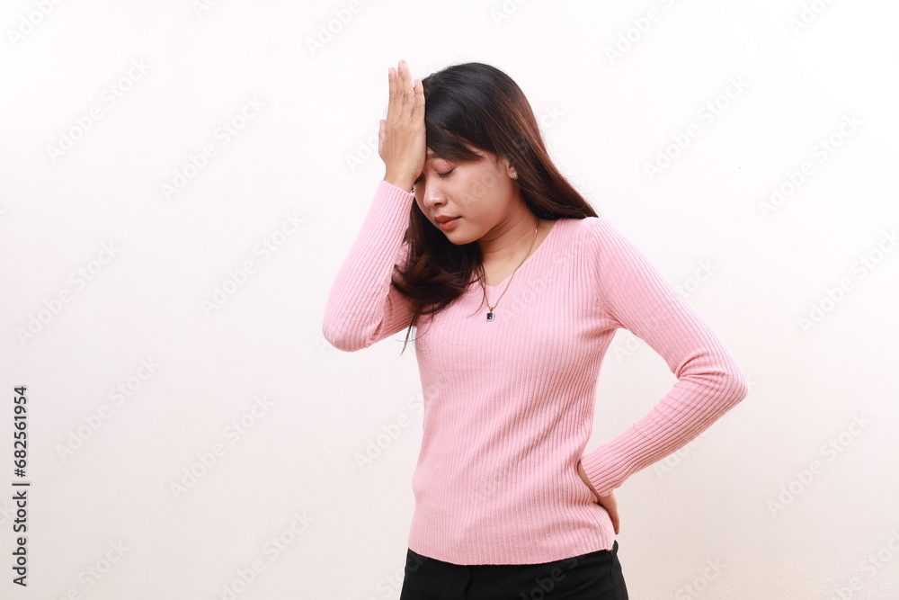 Worried young asian girl standing while holding head. Isolated on white background. Worried young asian girl standing while holding head. Isolated on white background.