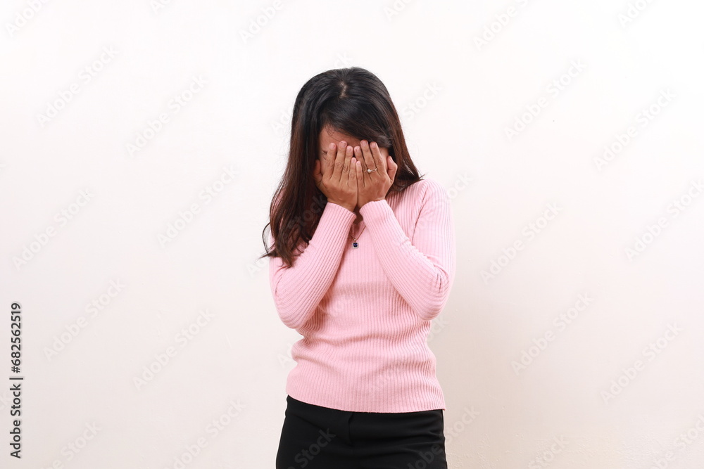 Stressed frustrated young asian girl standing while covering her face. Isolated on white Stressed frustrated young asian girl standing while covering her face. Isolated on white