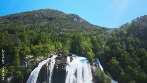 Furebergsfossen waterfall in Norway on a sunny day, aerial footage flying backwards  photo