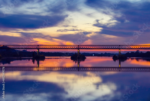 Old steel bridge at sunset. Bridge over the Tagus river, in the portuguese village of Chamusca - Ribatejo - Portugal. Bridge Isidro dos Reis - Chamusca