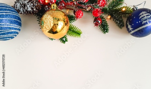 Spruce tree branch with cones on light background. Fir tree branches decorated with sharrow berries, cones, balls photo