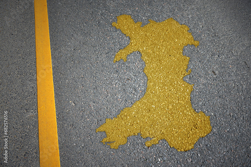 yellow map of wales country on asphalt road near yellow line. photo