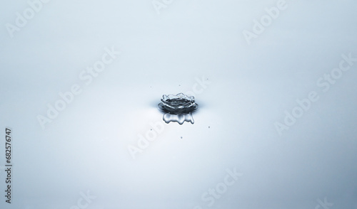Blue water circles surface with rings and ripples from drop splash