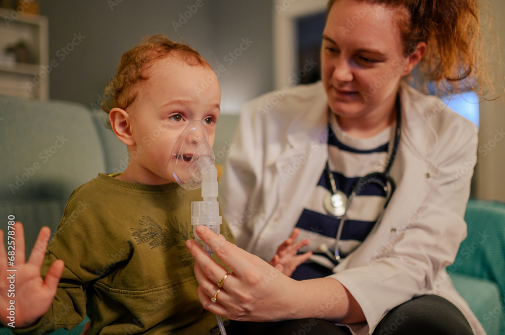 A boy breathing through medical mask in a living room.