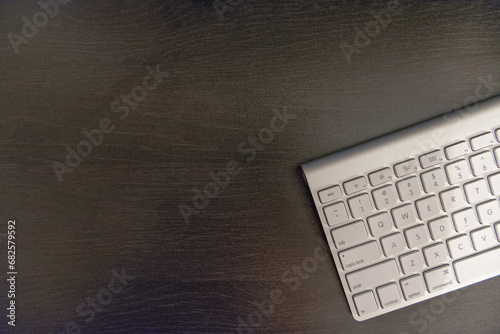 Modern Computer Keyboard on Dark Wooden Desk photo