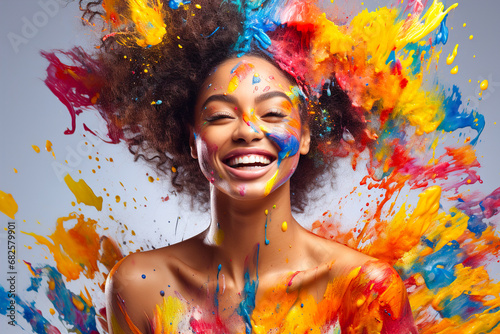 Laughing woman with splashes of colorful paint on her body and face. photo