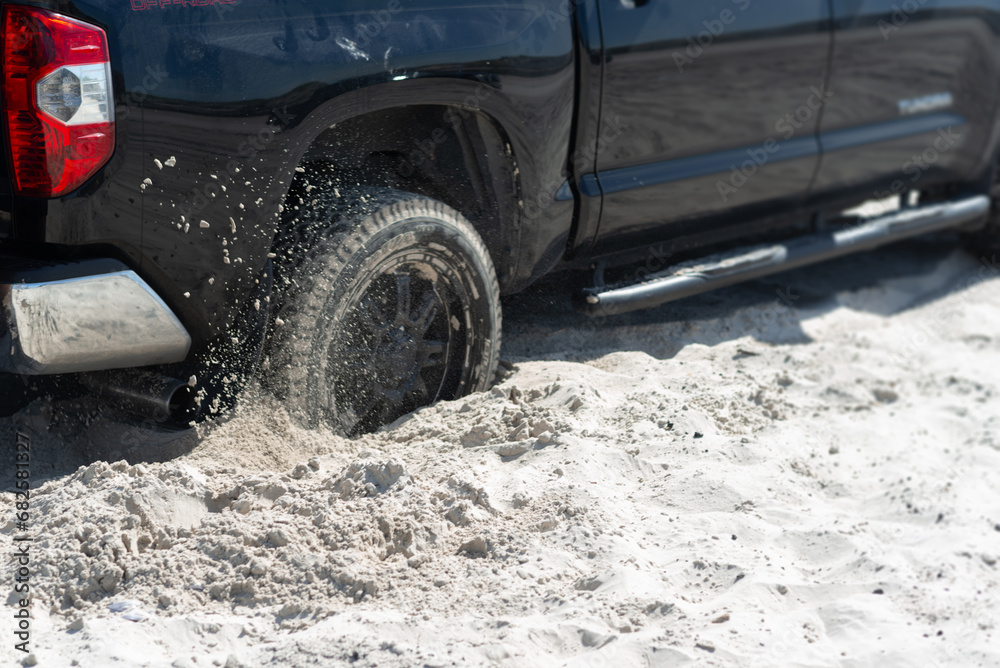 Obraz premium Truck Wheel Spinning in Soft Beach Sand