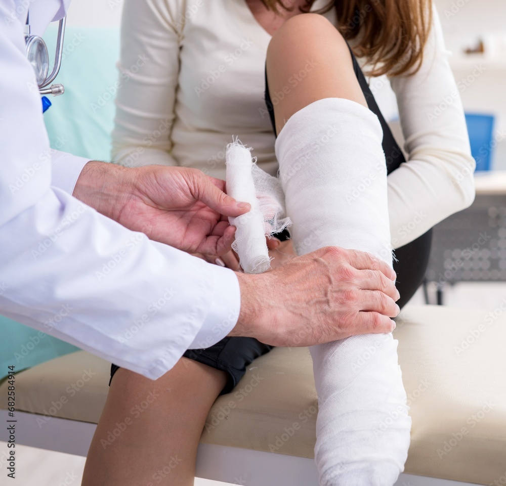 Young injured woman visiting experienced doctor traumatologist Young injured woman visiting experienced doctor traumatologist