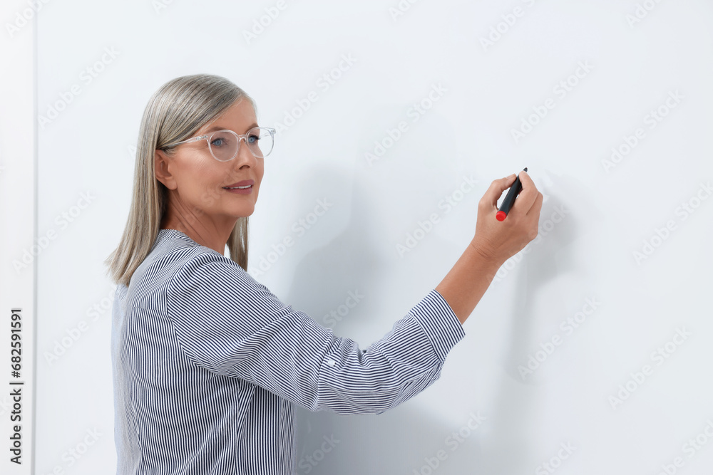 Portrait of professor explaining something at whiteboard indoors Portrait of professor explaining something at whiteboard indoors