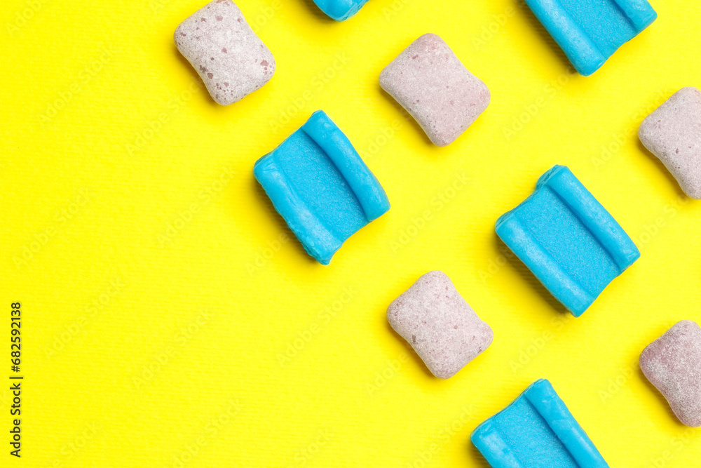Different bubble gums on yellow background, flat lay. Space for text Different bubble gums on yellow background, flat lay. Space for text