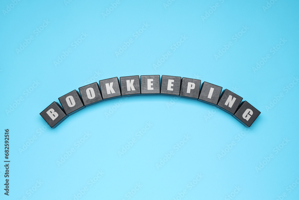 Word Bookkeeping made with black cubes on light blue background, top view
